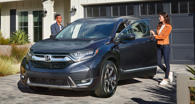 A woman and a man open the door of a Honda CR-V